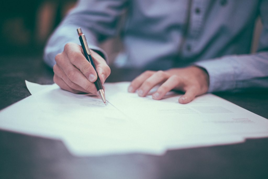 un homme qui signe des contrats